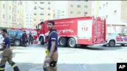 Rescuers arrive at the site of a residential building fire in Kuwait, June 12, 2024. (Kuwait TV via AP)