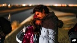 FILE - A couple from Cuba wait to be processed to seek asylum after crossing the border into the United States, Jan. 6, 2023, near Yuma, Ariz.