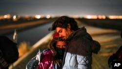 2023年1月6日，一對來自古巴的夫婦在亞利桑那州尤馬附近越過邊境進入美國後等待尋求庇護。 （美聯社照片）
