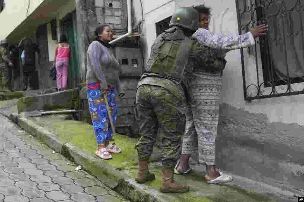  Soldados registran a mujeres mientras patrullan el lado sur de Quito, Ecuador, el 12 de enero de 2024, tras la aparente fuga de un poderoso líder de una pandilla de prisión. El presidente Daniel Noboa decretó el lunes estado de emergencia nacional, una medida que permite a las autoridades suspender los derechos de las personas y movilizar a los militares en lugares como las cárceles. (Foto AP/Dolores Ochoa). &nbsp; 