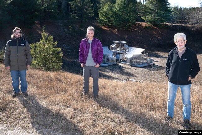 Anže Slosar, Sven Herrmann, and Paul O'Connor (pictured left to right) stand in front of BMX, the prototype radio telescope that was developed at Brookhaven. (Image Credit: Brookhaven National Laboratory)