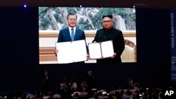 FILE - Members of the media watch a screen showing South Korea's then-President Moon Jae-in and North Korean leader Kim Jong Un hold documents after signing in Pyongyang, North Korea, at a press center for the inter-Korean summit in Seoul, South Korea, on Sept. 19, 2018.