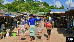 উখিয়ার জামতলী শরণার্থী শিবিরের একটি বাজারের মধ্য দিয়ে হেঁটে যাচ্ছে রোহিঙ্গা শরণার্থীরা। ২৪ আগস্ট, ২০২২। (ফাইল ছবি) 
