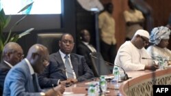 FILE —Senegal's President Macky Sall (C) looks on during the National Dialogue in Diamniadio on February 26, 2024.