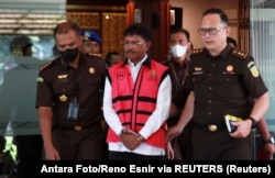Menteri Komunikasi dan Informatika Johnny G. Plat (rompi merah muda) berjalan di Kejaksaan Agung menyusul tuduhan korupsi di Jakarta, 17 Mei 2023. (Antara Foto/Reno Esnir via REUTERS)
