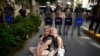 Two people sit next to a line of police officers blocking a street during the LGBTQ Pride March in Istanbul, Turkey, June 25, 2023.