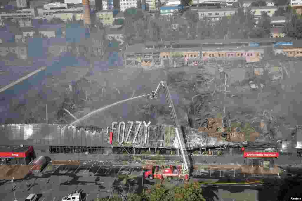 Rescuers work at a site of a shopping mall destroyed during a Russian military strike in Odesa, Ukraine.