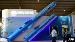 FILE - Pengunjung berjalan melewati model rudal jelajah supersonik Brahmos buatan India yang dipamerkan di Defense Expo 2022 di Gandhinagar, 18 Oktober 2022.