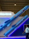 FILE - Visitors walk past a model of India's Brahmos supersonic cruise missile displayed at the Defence Expo 2022 in Gandhinagar on Oct. 18, 2022. 