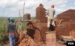 Builders construct a low-cost house for a cyclone victim in the Matindi area in Blantyre, Malawi. (Lameck Masina/VOA)