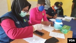 Petugas kesehatan di Puskesmas Maholog, Lore Timur, mempersiapkan obat tablet Praziquantel untuk pengobatan 26 warga yang terinfeksi schistosomiasis, Sabtu (11/2) (Foto: VOA/Yoanes Litha).