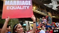 FILE - Seorang anggota komunitas LGBTQIA+ memegang plakat yang menyerukan kesetaraan pernikahan saat pawai "Pride" di Bangkok, 4 Juni 2023. Parlemen Thailand mengesahkan RUU pernikahan sesama jenis, 27 Maret 2024. (MANAN VATSYAYANA / AFP)