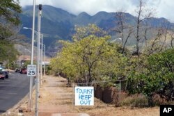 A 'Tourist Keep Out' sign is displayed in a neighborhood, Aug. 13, 2023, in Lahaina, Hawaii.