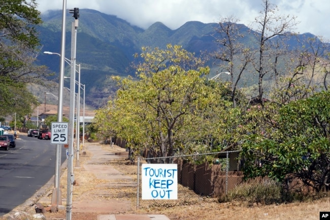 A 'Tourist Keep Out' sign is displayed in a neighborhood, Aug. 13, 2023, in Lahaina, Hawaii.