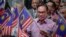 Perdana Menteri Malaysia Anwar Ibrahim mengibarkan bendera nasional usai menyampaikan pidato Hari Nasional di pusat konvensi di Putrajaya, Malaysia Rabu, 30 Agustus 2023. (AP/Vincent Thian)