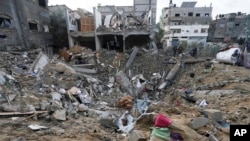Palestinians look at the destruction after an Israeli strike at a residential building in Deir al Balah, Gaza Strip, Jan. 14, 2024.