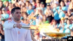 Greek Olympic medalist Ioannis Fountoulis lights the caldron with the Olympic Flame during the Olympic flame handover ceremony at Panathenaic stadium, where the first modern games were held in 1896, in Athens, April 26, 2024.