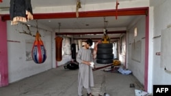 An Afghan man inspects gear at the Mellat boxing club, a day after an explosion took place at the site in Kabul, Oct. 27, 2023. 