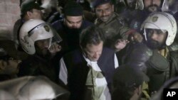 Police make way for former Prime Minister Imran Khan, center, outside a court in Lahore, Pakistan, March 17, 2023. The court suspended an arrest warrant for Khan, giving him a reprieve to travel to Islamabad and face charges in a graft case.