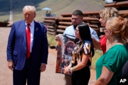 Donald Trump, during a stop Aug. 22, 2024, in Sierra Vista, Ariz, speaks with a group that includes Alexis Nungaray, center right, whose daughter was slain in June. Two men in the country illegally have been charged in her death.