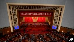 Para delegasi meninggalkan ruangan usai sesi pembukaan Kongres Nasional Rakyat China di Beijing, Minggu, 5 Maret 2023. (Foto: Ng Han Guan/AP Photo)