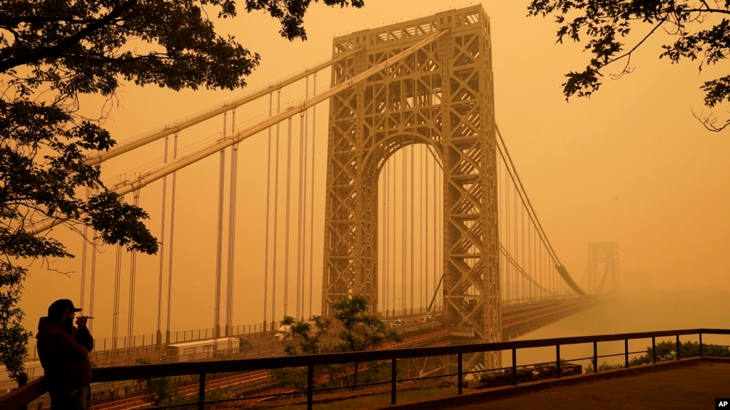 A man talks on his phone as he looks through wildfire haze at the George Washington Bridge in the U.S. state of New Jersey, June 7, 2023.