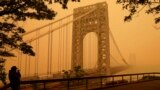 A man talks on his phone as he looks through wildfire haze at the George Washington Bridge in the U.S. state of New Jersey, June 7, 2023.