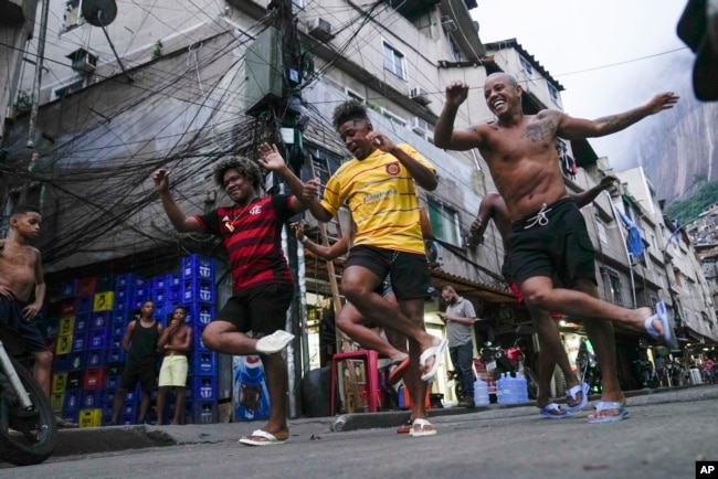 Youth perform a street dance style known as passinho for their social media accounts, in the Rocinha favela of Rio de Janeiro, Brazil, April 11, 2024. (AP Photo/Silvia Izquierdo, File)