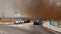 Kendaraan meninggalkan daerah yang diselimuti asap akibat kebakaran setelah roket yang diluncurkan dari Lebanon selatan menghantam daerah di Dataran Tinggi Golan yang dianeksasi Israel, 4 Juli 2024. (Jalaa MAREY / AFP)