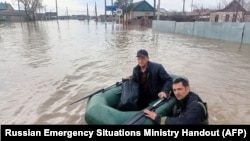 Tim SAR mengarungi jalan yang banjir dalam perjalanan mengevakuasi warga di wilayah Orenburg, tenggara ujung selatan Pegunungan Ural, Rusia, Sabtu, 6 April 2024. (Foto: Russian Emergencies Ministry/AFP)