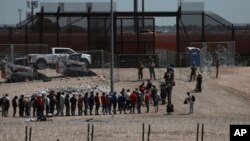 FILE - Migrants line up after being detained by U.S. authorities at the U.S.-Mexico border in Ciudad Juarez, Mexico, April 30, 2023. 