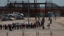 FILE - Migrants line up after being detained by U.S. authorities at the U.S.-Mexico border in Ciudad Juarez, Mexico, April 30, 2023. 