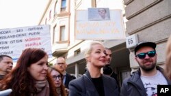 Yulia Navalnaya, center, widow of Alexey Navalny, stands in a queue with other voters at a polling station near the Russian embassy in Berlin, after noon local time, on Sunday, March 17, 2024.