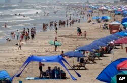 Visitors crowd beaches in Port Aransas, Texas, before Hurricane Beryl's arrival, July 6, 2024. Some Texas coastal cities called for voluntary evacuations in areas prone to flooding, banned beach camping, and urged tourists to move recreational vehicles from coastal parks.