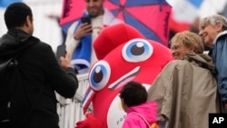 Spectators pose with the Olympic Phryge, France's Olympic mascot, ahead of rowing competitions at the 2024 Summer Olympics, in Vaires-sur-Marne, France, July 27, 2024.