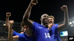 France's Jean-Philippe Mateta (14) celebrates with teammates after scoring his side's second goal in extra time during the men's semifinal soccer match between France and Egypt, at Lyon Stadium, during the 2024 Summer Olympics, Aug. 5, 2024.