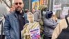 During a protest in France, a demonstrator brandishes sign saying 'Macron, scornful of the Republic," March 23, 2023.