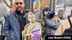 During a protest in France, a demonstrator brandishes sign saying 'Macron, scornful of the Republic," March 23, 2023.