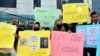 FILE — Afghan university students in Quetta, Pakistan, chant slogans and hold placards during a protest against the ban on university education for women in their home country, Dec. 24, 2022. 
