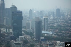 Kabut asap menyelimuti kawasan bisnis utama di Jakarta, Indonesia, Jumat, 11 Agustus 2023. (AP/Dita Alangkara)