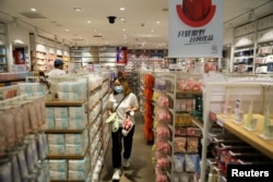 FILE - A customer shops at a store of Chinese retailer MINISO Group in Beijing, Sept. 13, 2021. China is struggling to raise economic growth back to prepandemic levels, with consumption remaining low and troubles in the property sector persisting.