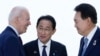 U.S. President Joe Biden, left, talks with Japan's Prime Minister Fumio Kishida and South Korean President Yoon Suk Yeol, right, ahead of a trilateral meeting on the sidelines of the G7 Summit in Hiroshima, Japan, May 21, 2023.