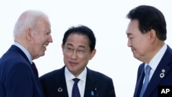 FILE - From left, U.S. President Joe Biden talks with Japan's Prime Minister Fumio Kishida and South Korean President Yoon Suk Yeol ahead of a trilateral meeting on the sidelines of the Group of Seven summit in Hiroshima, Japan, May 21, 2023.