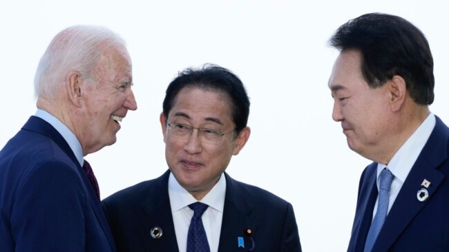 U.S. President Joe Biden, left, talks with Japan's Prime Minister Fumio Kishida and South Korean President Yoon Suk Yeol, right, ahead of a trilateral meeting on the sidelines of the G7 Summit in Hiroshima, Japan, May 21, 2023.