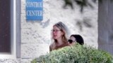 Elizabeth Holmes, left, is escorted by prison officials into a federal women’s prison camp on May 30, 2023, in Bryan, Texas. Holmes will spend the next 11 years serving her sentence for overseeing a blood-testing hoax at Theranos.