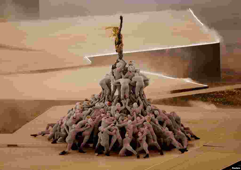 The Golden Voyager stands atop a pile of masked dancers in a performance during the closing ceremony of the Paris Olympics at the Stade de France, Saint- Denis, France, Aug. 11, 2024.