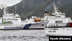 中国海警船进入有争议的尖阁列岛（中国称钓鱼岛）海域，在日本海岸警卫队巡逻舰旁驶过。（2024年4月27日）