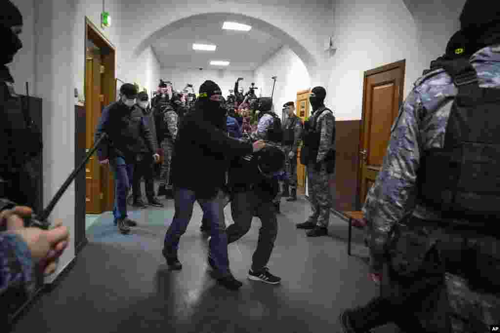 A suspect in the Crocus City Hall shooting on Friday is escorted by police officers in the Basmanny District Court, in Moscow, Russia, March 24, 2024. 