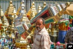 Seorang pria membawa lentera tradisional di pasar Sayyeda Zeinab menjelang Ramadan, di Kairo, Mesir, Selasa, 21 Maret 2023. (AP/Amr Nabil)