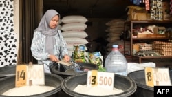 Seorang penjual menunggu pelanggan di kios beras di Jakarta pada 28 Februari 2024, di tengah lonjakan harga dan kekurangan bahan pokok. (Foto: Adek Berry/AFP)